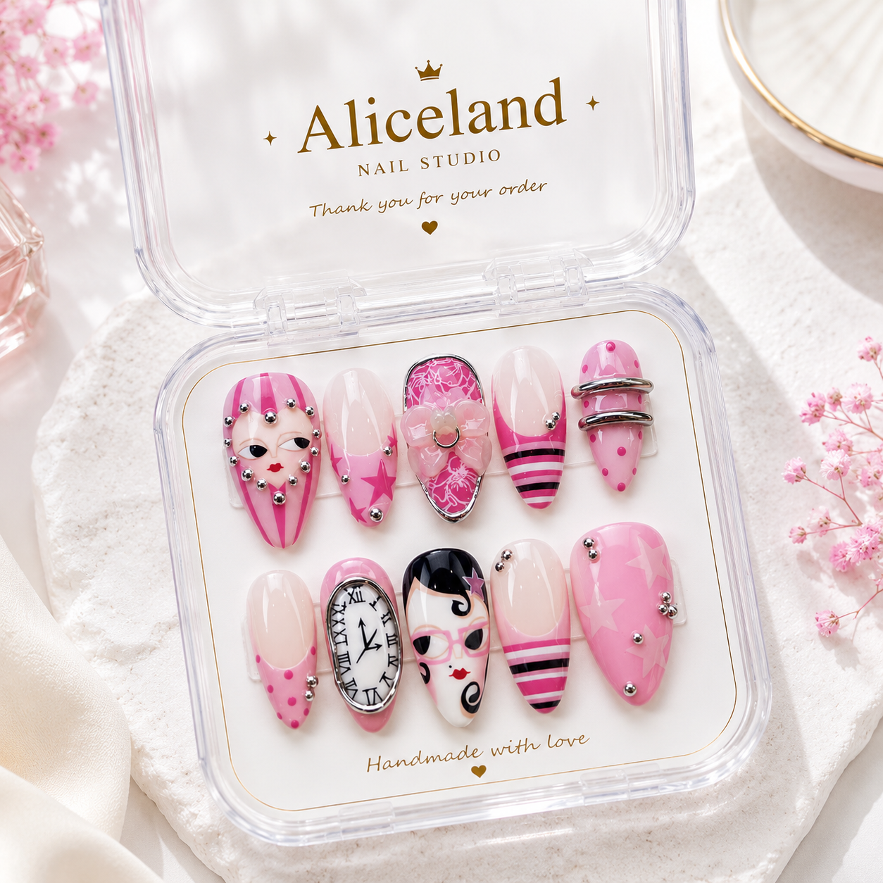 Pink Muse almond press on nails featuring coquette-inspired fashion illustrations, stars, rhinestones and glossy pink nail art